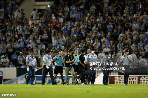 Match officials are protected by security staffs at the half time during the J.League J1 match between Jubilo Iwata and Vissel Kobe at Yamaha Stadium...