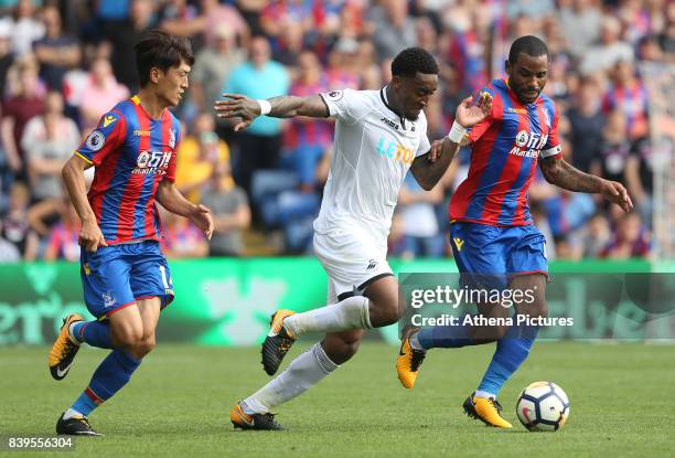 Leroy Fer of Swansea City is marked by Lee Chung-yong and Jason Puncheon of Crystal Palace during the Premier League match between Crystal Palace and...