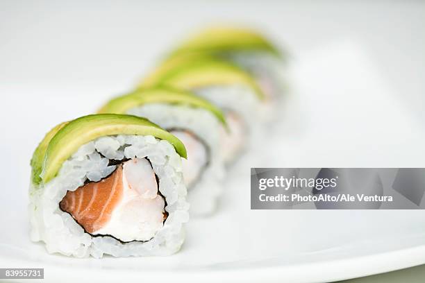 row of maki sushi on sushi plate, close up - surimi photos et images de collection