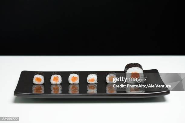maki sushi arranged on plate, one piece larger than the rest - sushi plate stock pictures, royalty-free photos & images