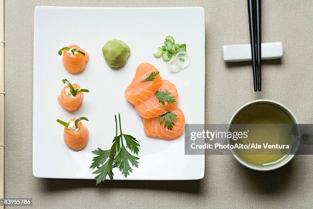 assorted sushi arranged on large sushi plate with tea and chopsticks alongside - tea cup overhead view photos et images de collection