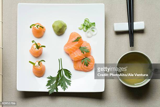 assorted sushi arranged on large sushi plate with tea and chopsticks alongside - slätpersilja bildbanksfoton och bilder