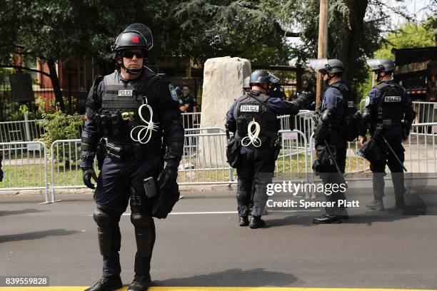 Riot police keep guard beside a Confederate monument in Fort Sanders in advance of a planned white supremacist rally and counter-protest around the...