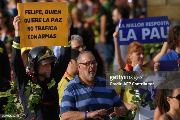 Fireman holds a placard reading "Felipe, who wants peace doesn't smuggle weapons" during a march against terrorism which slogan is #NoTincPor in...