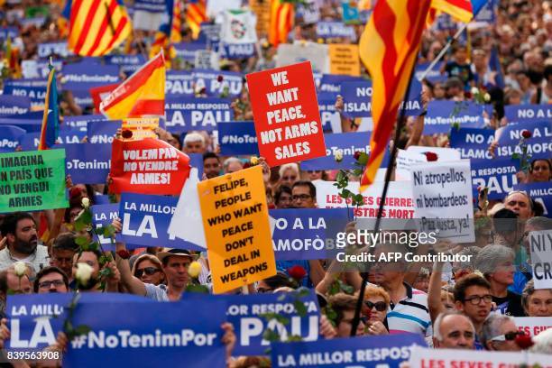 People hold placards and Catalan flags during a march against terrorism which slogan will be #NoTincPor in Barcelona on August 26 following the...