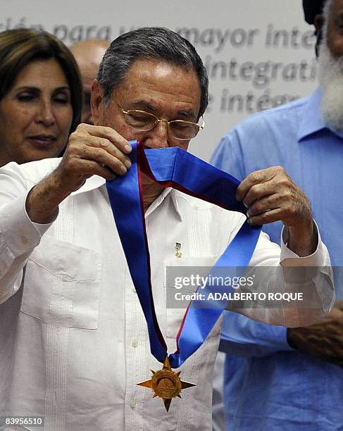 Cuban President Raul Castro holds the Honourary Order, given by the Caricom to his brother and former Cuban President Fidel Castro, during the...