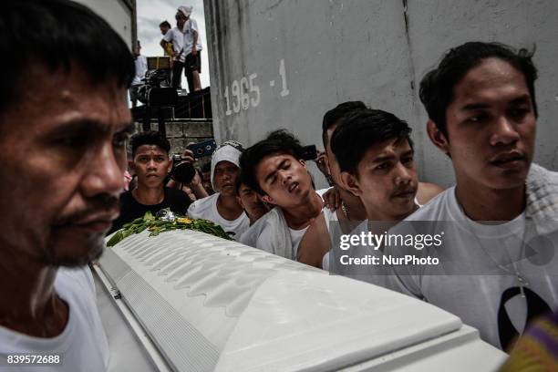 Catholic priests, relatives, and friends carry the coffin of Kian Loyd Delos Santos during his funeral rites in Caloocan, Metro Manila, Philippines,...