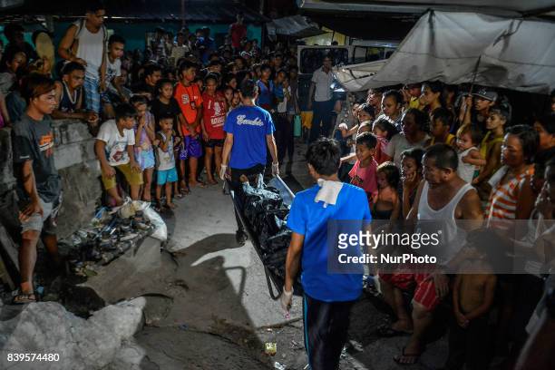 Funeral workers carry the body of one of three men killed during a police operation against illegal drugs in Caloocan, Metro Manila, Philippines,...