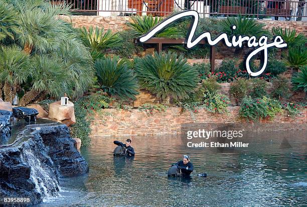 Workers make last-minute adjustments to FireShooters before the premiere of the newly-redesigned volcano attraction in front of The Mirage Hotel &...