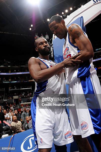 Baron Davis of the Los Angeles Clippers is restrained by teammate Marcus Camby after being fouled during the game against the Orlando Magic at...