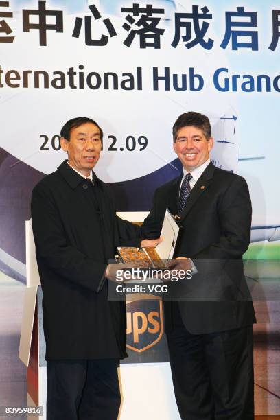 Dan Brutto CEO of United Parcel Services shakes hands with Wu Nianzu, Chairman and President of Shanghai Airport Authority in the unveiling ceremony...