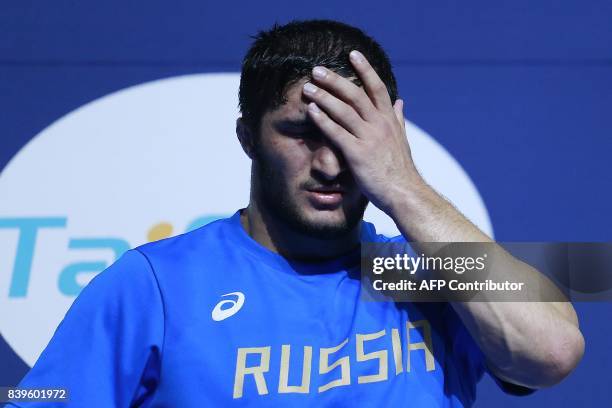 Russia's silver medallist Abdulrashid Sadulaev reacts on the podium during the medal ceremony for the men's freestyle wrestling -97kg category at the...
