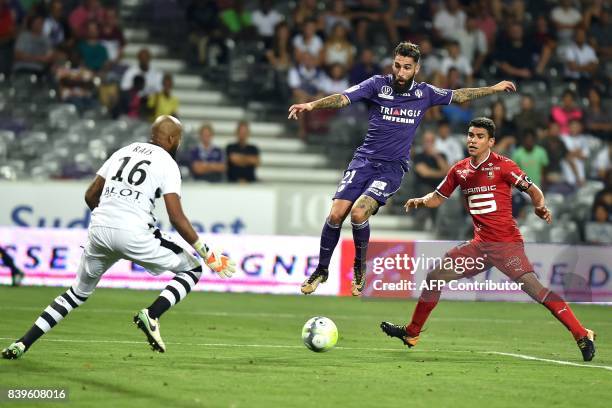Rennes' Algerian goalkeeper Rais M'Bolhi tries to block a shot on goal by Toulouse's Swedish midfielder Jimmy Durmaz during the French L1 football...