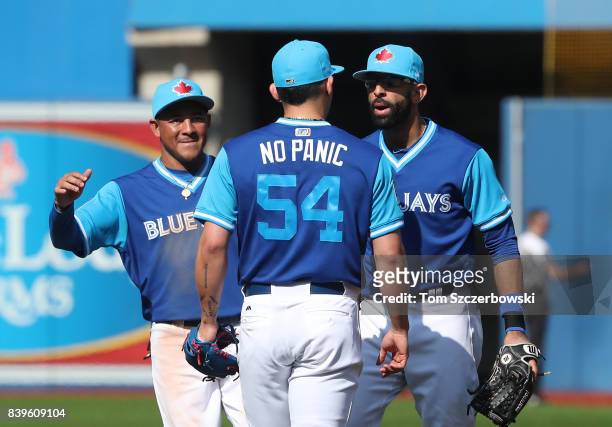 Roberto Osuna of the Toronto Blue Jays celebrates their victory with Jose Bautista and Ezequiel Carrera during MLB game action against the Minnesota...