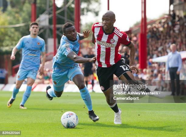 Brentford's Kamohelo Mokotjo holds off the challenge from Wolverhampton Wanderers' Bright Enobakhare during the Sky Bet Championship match between...