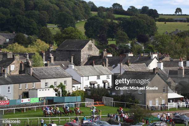 General view of the field as they pass the village of Cartmel during the Hadwins Motor Group TBA Mares' Handicap Hurdle Race at Cartmel Racecourse on...