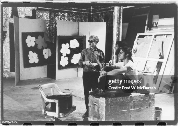 Portrait of American pop artist Andy Warhol , future film historian P Adams Sitney , and poet Gerard Malanga in the Factory, Warhol's studio, New...