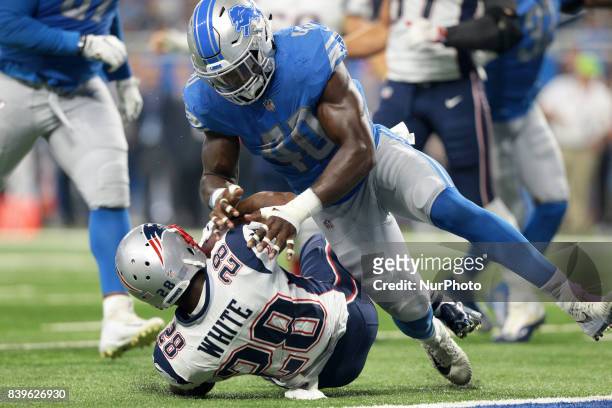 New England Patriots running back James White gets tacled by Detroit Lions linebacker Jarrad Davis during the first half of an NFL football game in...