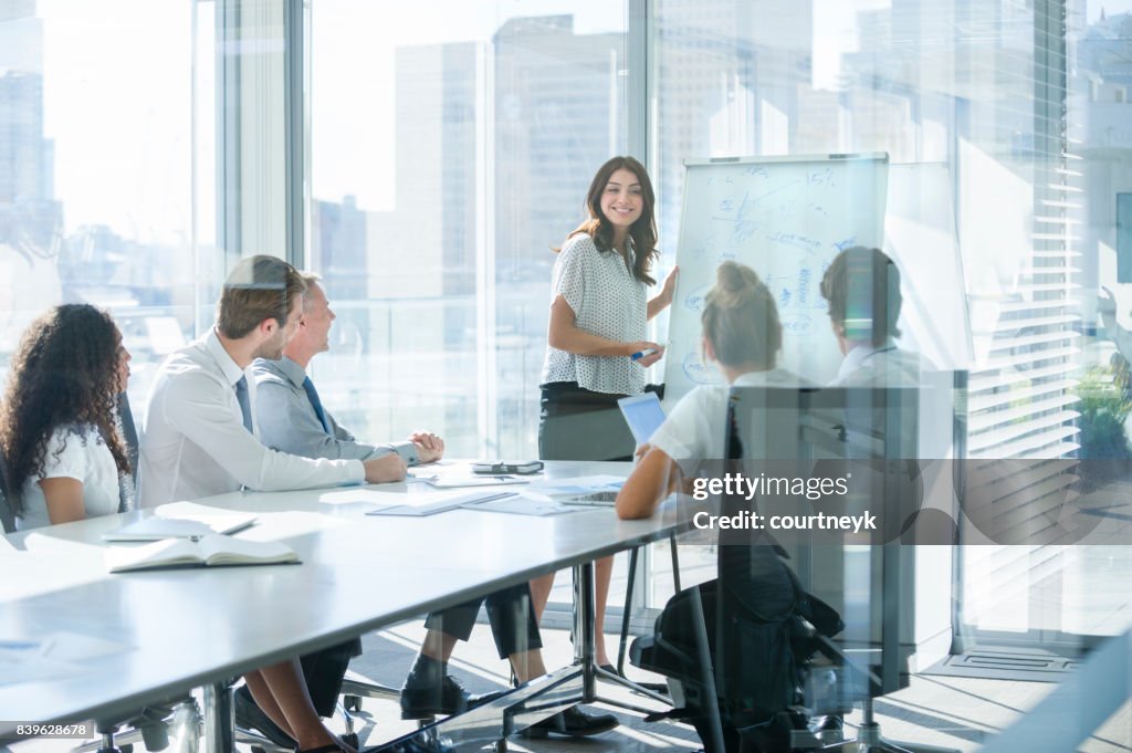 Woman giving a presentation to her team.