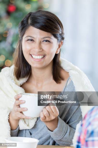 attractive woman enjoys a hot beverage at christmastime - hot filipina women stock pictures, royalty-free photos & images