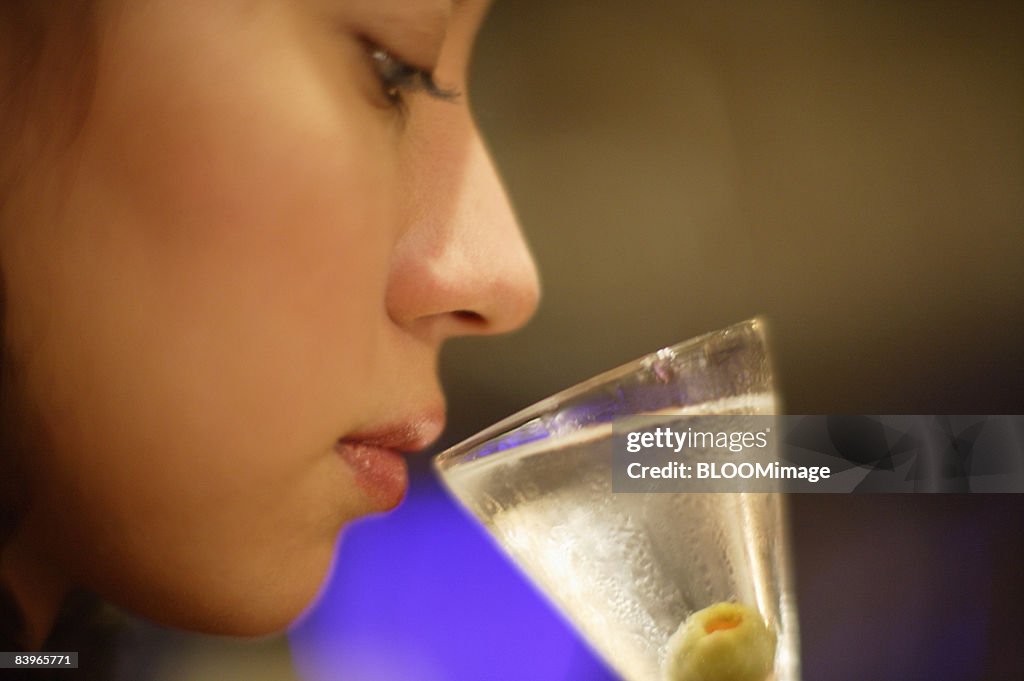 Woman having cocktail at bar counter