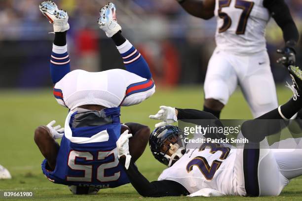 Running back LeSean McCoy of the Buffalo Bills is tackled by strong safety Eric Weddle of the Baltimore Ravens in the first half during a preseason...