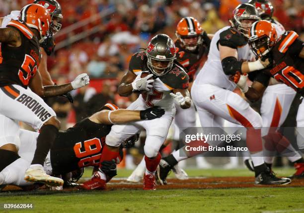 Running back Jacquizz Rodgers of the Tampa Bay Buccaneers is stopped by defensive end Jamie Meder of the Cleveland Browns during the first quarter of...