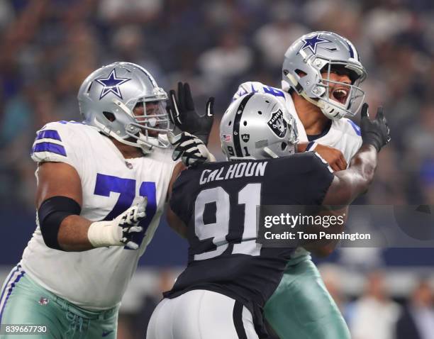 La'el Collins of the Dallas Cowboys tries to protect Dak Prescott of the Dallas Cowboys as he is hit by Shilique Calhoun of the Oakland Raiders in...