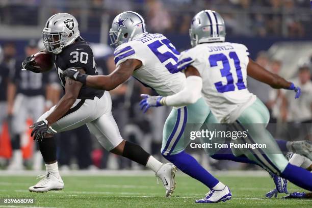 Jalen Richard of the Oakland Raiders carries the ball against Anthony Hitchens of the Dallas Cowboys and Byron Jones of the Dallas Cowboys in the...