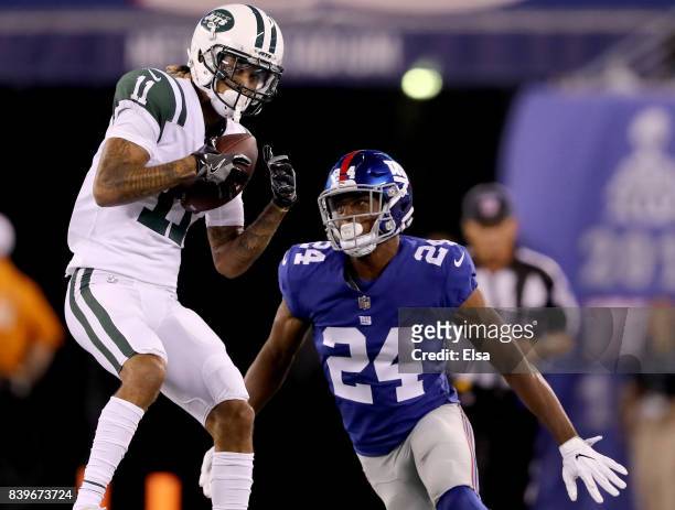 Robby Anderson of the New York Jets makes the catch as Eli Apple of the New York Giants defends in the first half during a preseason game on August...