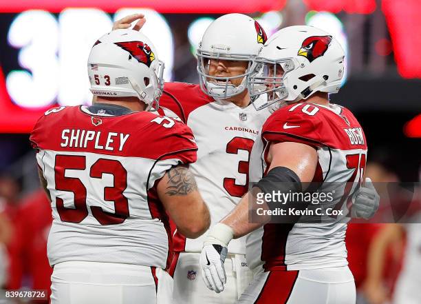 Carson Palmer of the Arizona Cardinals reacts after passing for a touchdown against the Atlanta Falcons with A.Q. Shipley and Evan Boehm at...