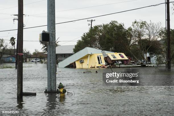 Flooding and a damaged home are seen after Hurricane Harvey hit Rockport, Texas, U.S., on Saturday, Aug. 26, 2017. As Harvey's winds die down,...