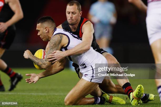 James Kelly of the Bombers tackles Harley Bennell of the Dockers during the round 23 AFL match between the Essendon Bombers and the Fremantle Dockers...