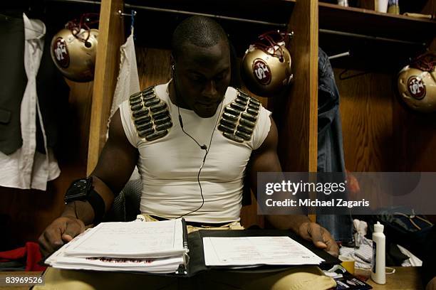 Takeo Spikes of the San Francisco 49ers reviews plays in the locker room before an NFL football game against the Dallas Cowboys at Texas Stadium on...