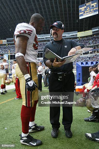 Greg Manusky meets with Manny Lawson of the San Francisco 49ers during an NFL football game against the Dallas Cowboys at Texas Stadium on November...