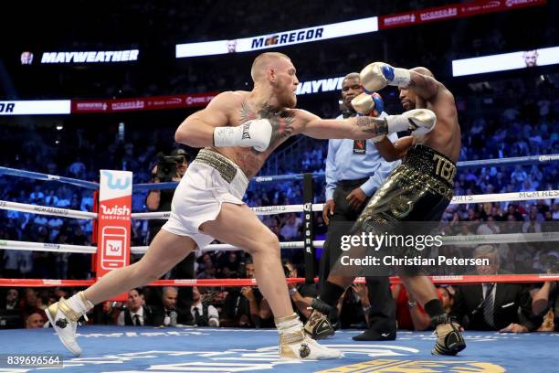 Conor McGregor throws a punch at Floyd Mayweather Jr. During their super welterweight boxing match on August 26, 2017 at T-Mobile Arena in Las Vegas,...