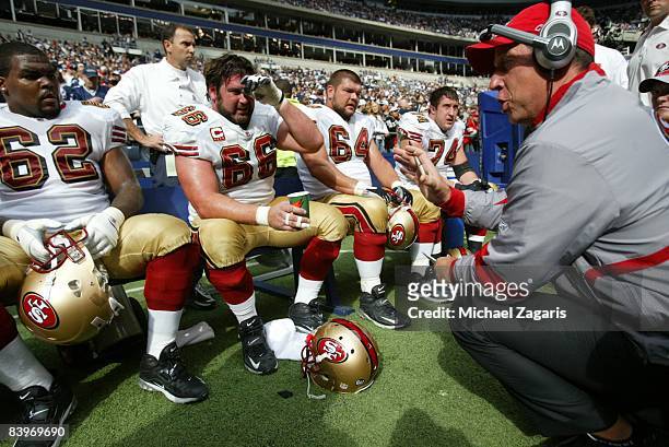 Chris Foerster meets with the offensive line of the San Francisco 49ers during an NFL football game against the Dallas Cowboys at Texas Stadium on...