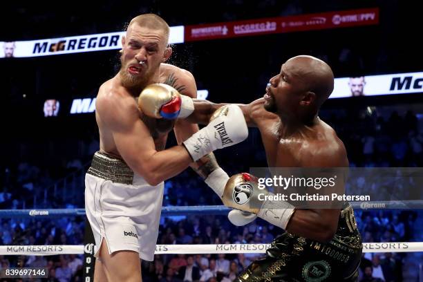 Floyd Mayweather Jr. Throws a punch at Conor McGregor during their super welterweight boxing match on August 26, 2017 at T-Mobile Arena in Las Vegas,...