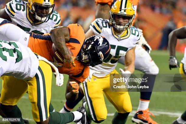 Denver Broncos running back Stevan Ridley gets upended by Green Bay Packers defensive back Aaron Taylor after a short gain during the fourth quarter...