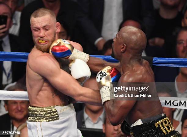 Floyd Mayweather Jr. Throws a punch at Conor McGregor during their super welterweight boxing match on August 26, 2017 at T-Mobile Arena in Las Vegas,...