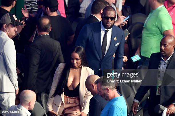 Player LeBron James and his wife Savannah Brinson attend the super welterweight boxing match between Floyd Mayweather Jr. And Conor McGregor on...