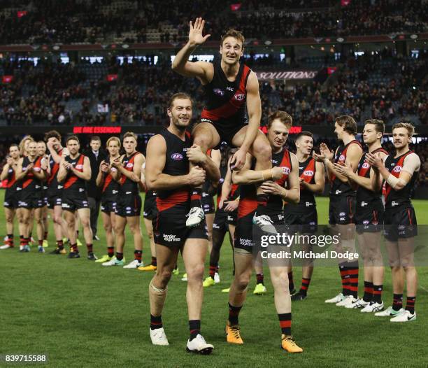 Jobe Watson of the Bombers gets carried off for his last home match by Tom Bellchambers and Brendon Goddard during the round 23 AFL match between the...