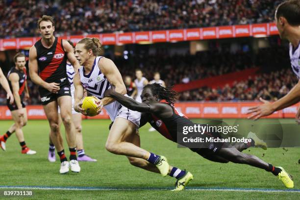 Anthony McDonald-Tipungwuti of the Bombers tackles Nat Fyfe of the Dockers during the round 23 AFL match between the Essendon Bombers and the...