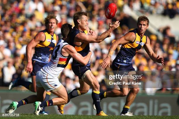 Sam MItchell of the Eagles gets his handball away while being tackled during the round 23 AFL match between the West Coast Eagles and the Adelaide...