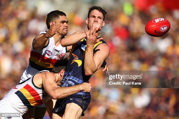 Jack Redden of the Eagles gets his handball away while being tackled by Charlie Cameron and Richard Douglas of the Crows during the round 23 AFL...