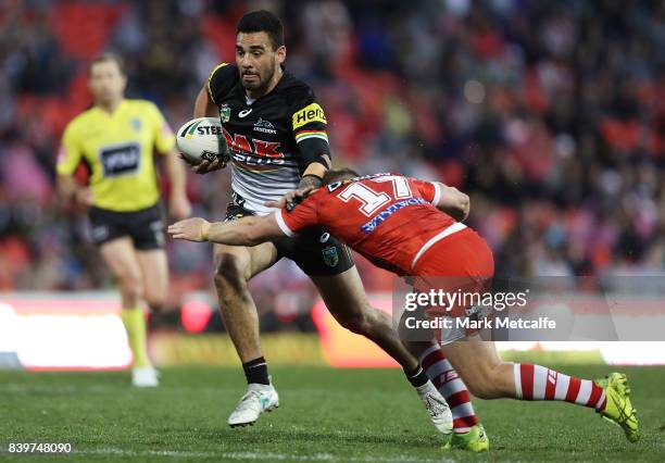 Tyrone May of the Panthers is tackled by Josh McCrone of the Dragons during the round 25 NRL match between the Penrith Panthers and the St George...