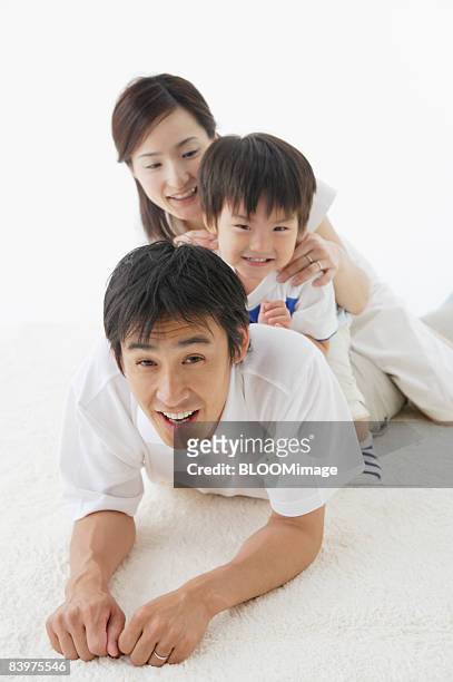 portrait of family, mother and son riding on father's back, studio shot - hot boy body stock pictures, royalty-free photos & images
