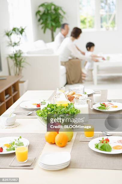 served table with family in background, focus on foreground - light vivid children senior young focus foto e immagini stock