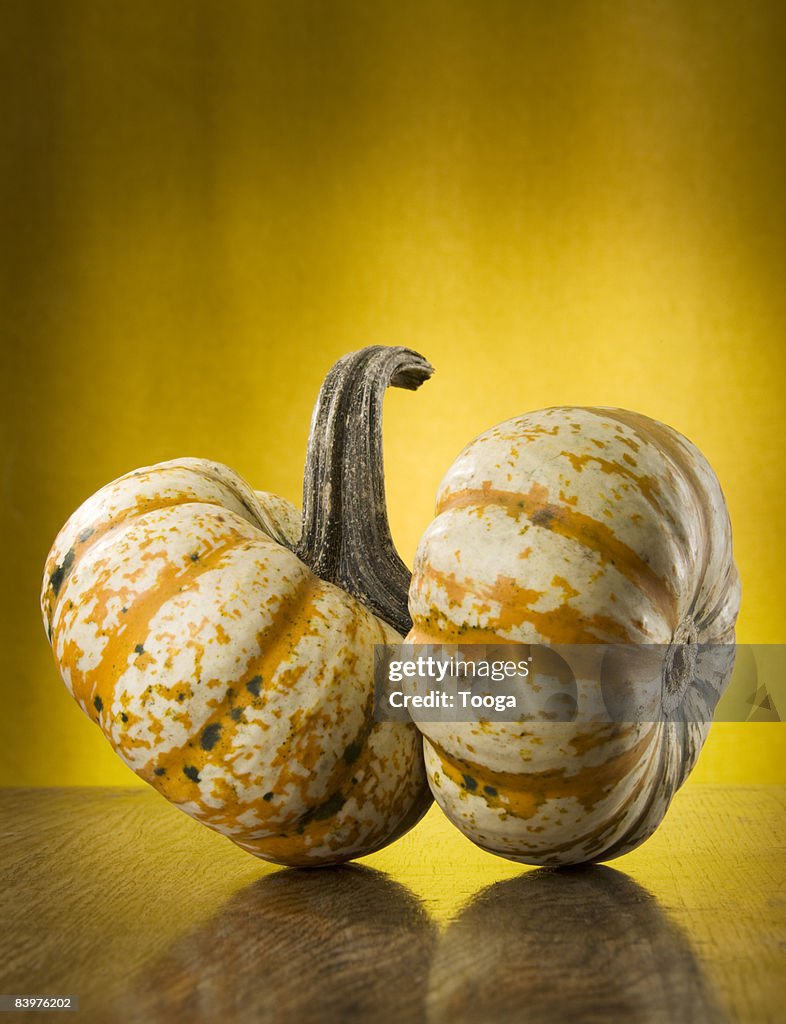 Twin pumpkins on wood surface