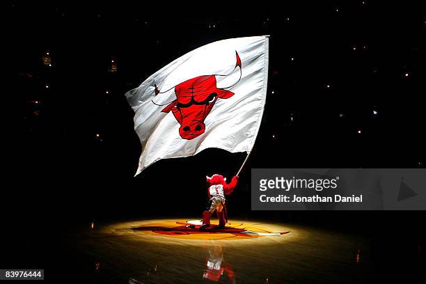 Benny the Bull, mascot for the Chicago Bulls, waves a giant flag with the Bulls' logo on it during pregame festivities against the New York Knicks at...
